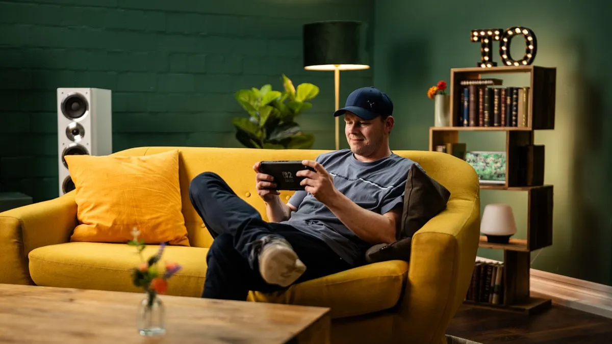 Sebastian sitzt auf einem Sofa und zockt mit der Nintendo Switch 2.