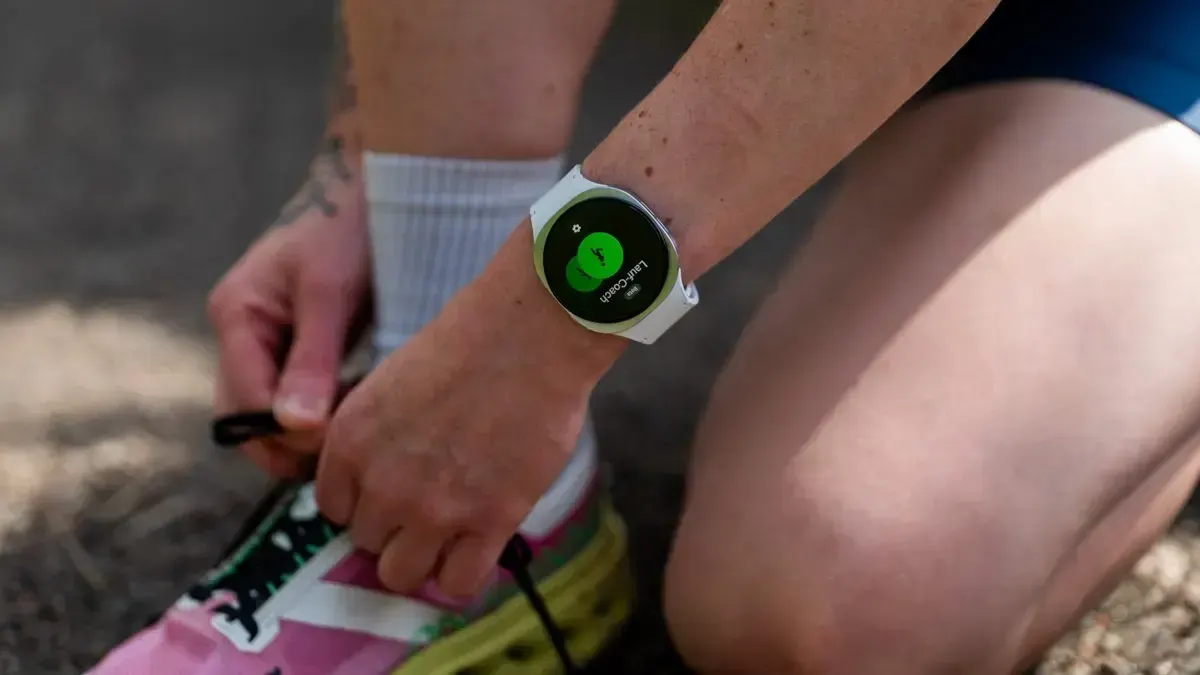 Die Samsung Galaxy Watch8 am Handgelenk von TURN ON Redakteurin Franzi, die sich die Laufschuhe zubindet.
