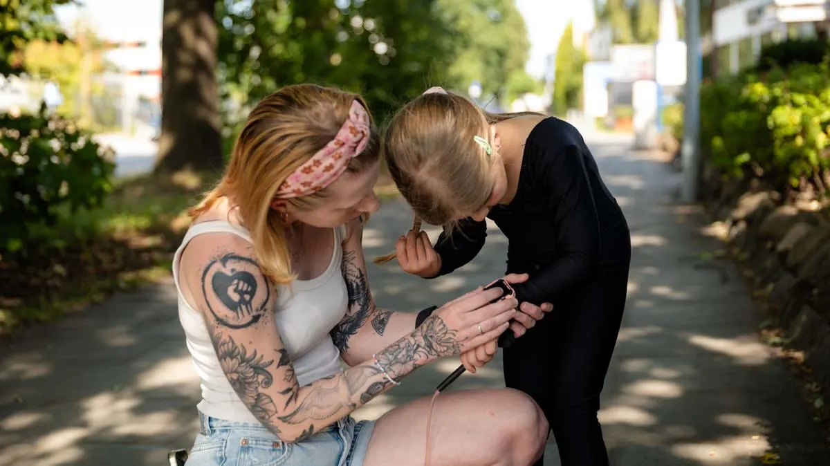 Franzi und ihre Tochter sind über die imoo Z7 gebeugt, Franzi stellt etwas auf der Uhr ein.