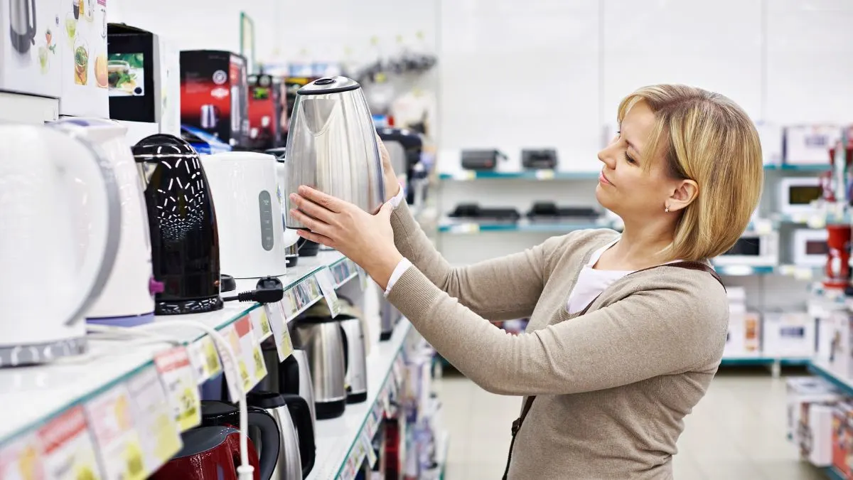 Eine Frau sieht sich einen Wasserkocher im Fachhandel an.
