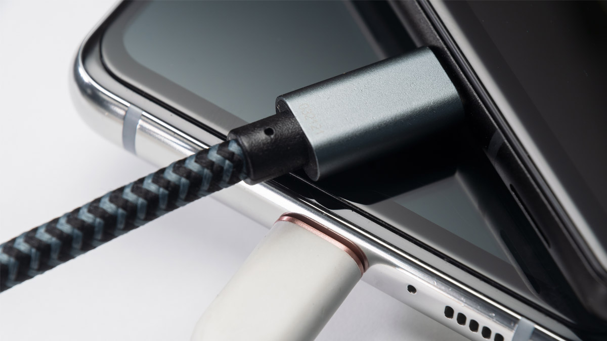 Zwei Smartphones mit eingesteckten Ladekabeln liegen übereinander gestapelt.