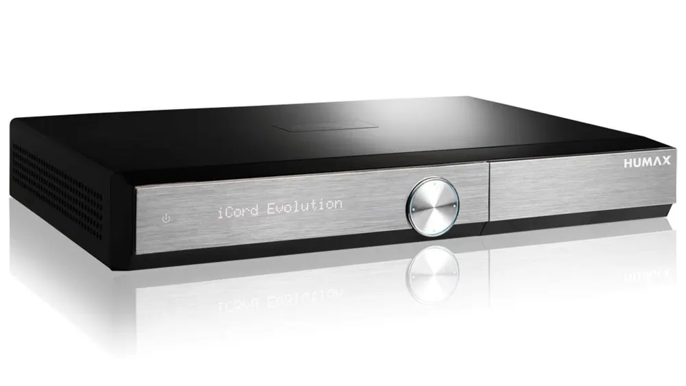 Ein schwarzer Humax iCord Evolution Receiver mit silberner Blende und Drehknopf steht auf einer glänzenden Oberfläche.