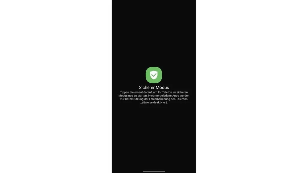 Schwarzer Bildschirm mit dem Text "Sicherer Modus" und Informationen zum Neustart des Telefons im sicheren Modus. Grünes Schild-Symbol.