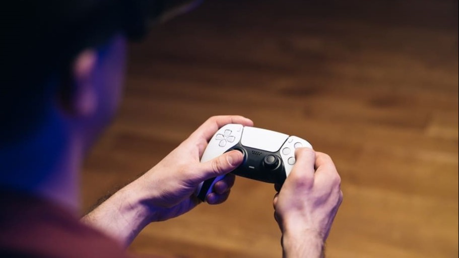 Person hält einen weißen DualSense‑Controller in beiden Händen, aufgenommen von hinten, als stimmungsvolles Szenenbild für Inhalte zur SONY PlayStation®5 Pro 2 TB Konsole.