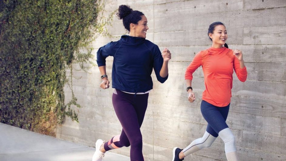 Zwei Frauen mit einer Fitbit Charge 3 am Arm joggen.