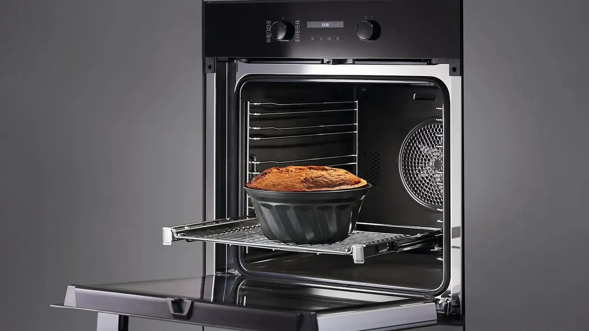 Der geöffnete Einbaubackofen Miele H 2766-1 BP mit einem frisch gebackenen Kuchen auf ausgezogenem Rost.