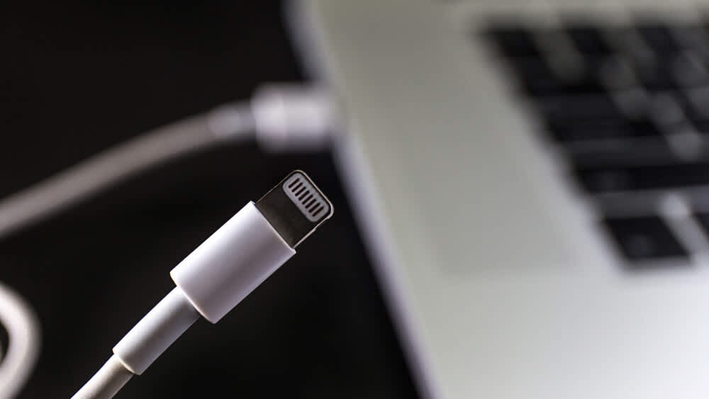 Ein Apple-Ladekabel ist mit einem MacBook verbunden.