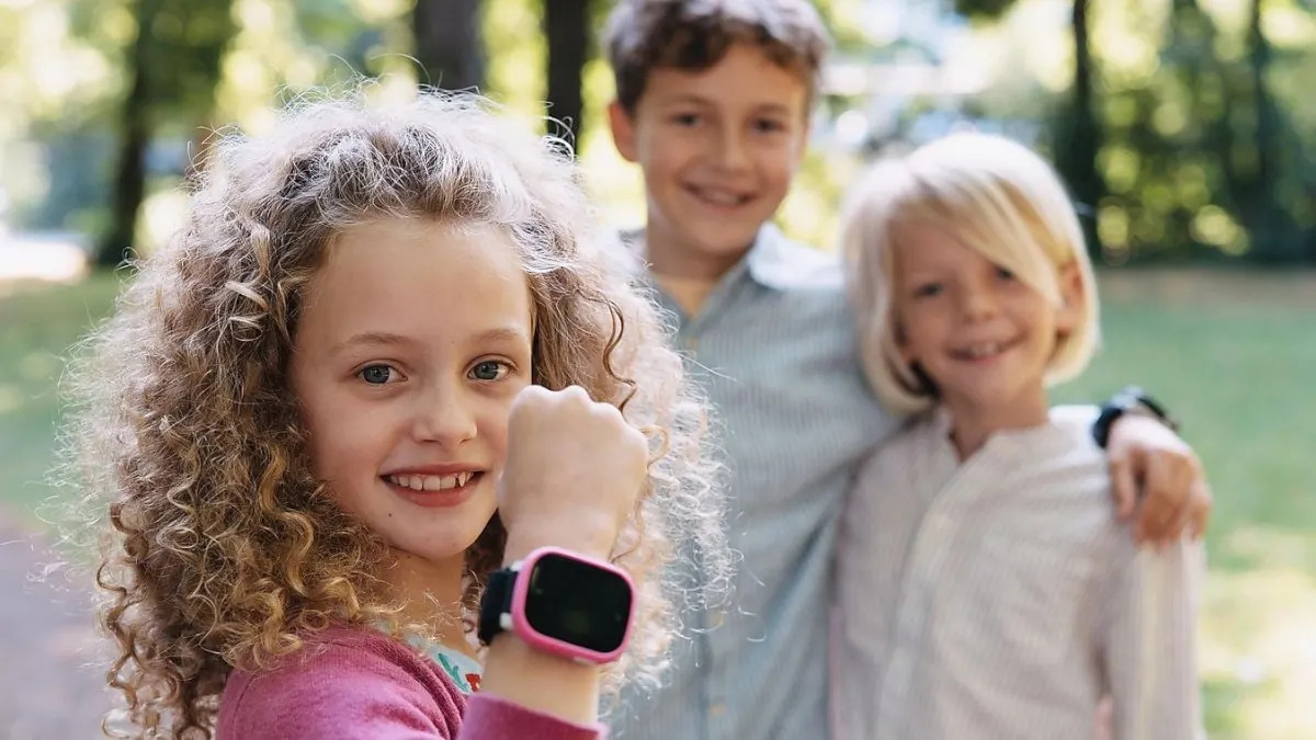 Ein lächelndes Kind trägt die Xplora X6Play (2. Generation) am Arm.