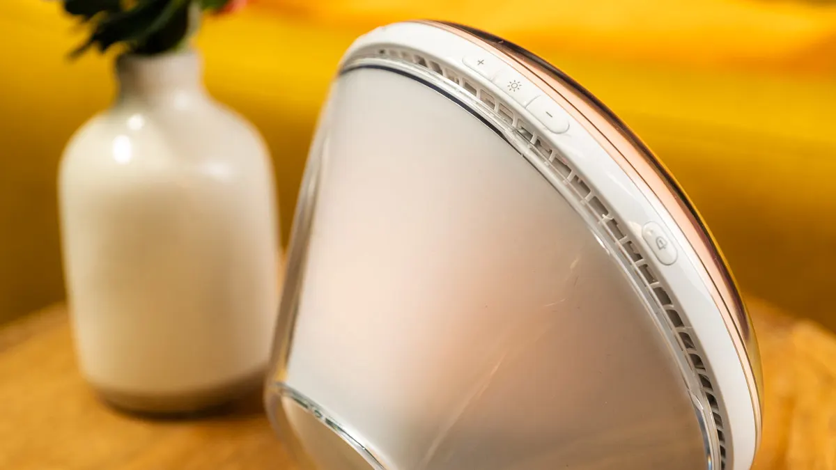 Ein Philips-Lichtwecker ist von der Seite zu sehen, daneben steht eine Vase.