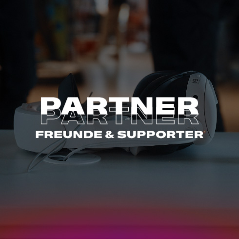 Ein Innenraum mit Neonlinien und Text "Partner Freunde & Supporter" im Vordergrund. Eine Person sitzt an einem Tisch.