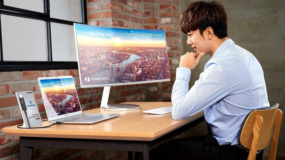 Mann sitzt vor zwei Bildschirmen 