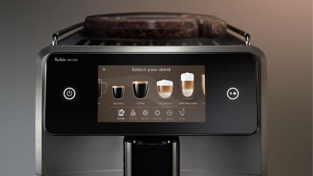 Ein Kaffeevollautomat mit Touchscreen-Display zur Getränkeauswahl und Bedienelementen für Start und Navigation.