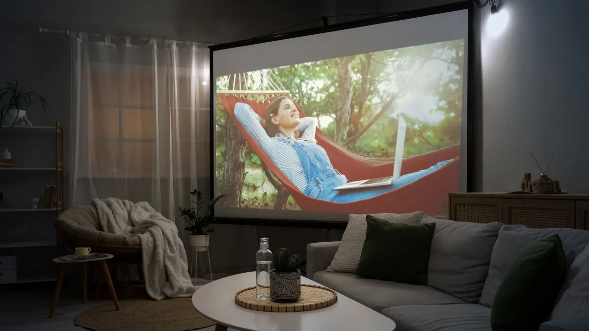 Auf einer Leinwand im Wohnzimmer läuft ein Film.