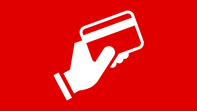 Weiße Hand hält eine Kreditkarte vor einem roten Hintergrund. Die Karte hat einen weißen Rand und einen roten Streifen.