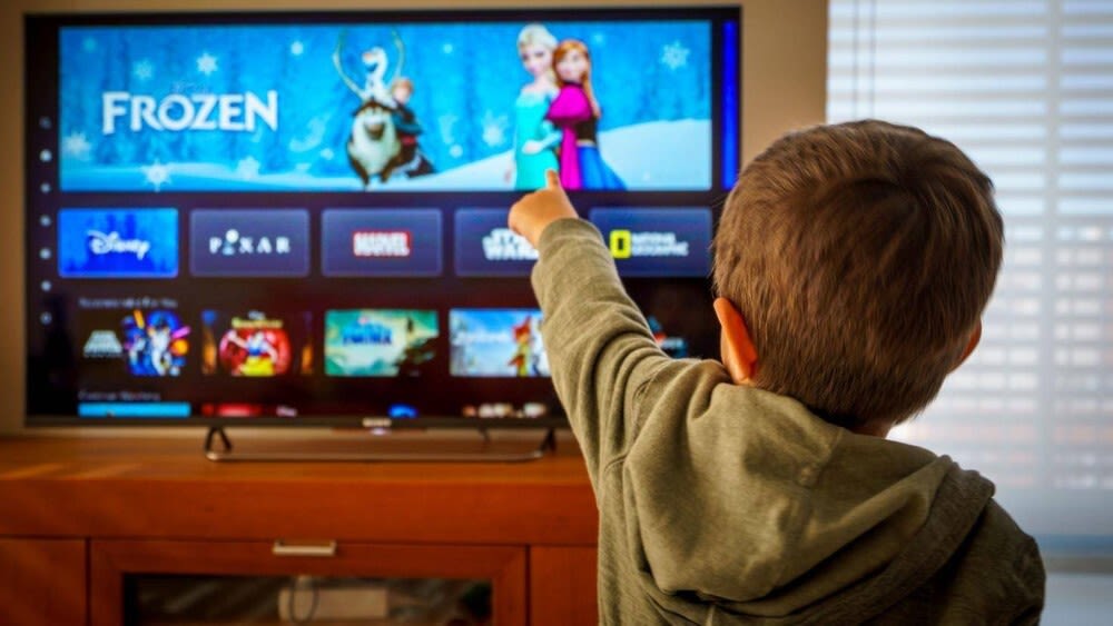 Kleiner Junge zeigt auf Fernseher