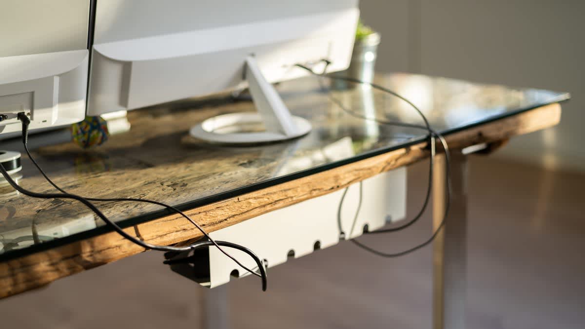 Kabel verlaufen ordentlich durch das integrierte Kabelmanagement eines Schreibtischs.