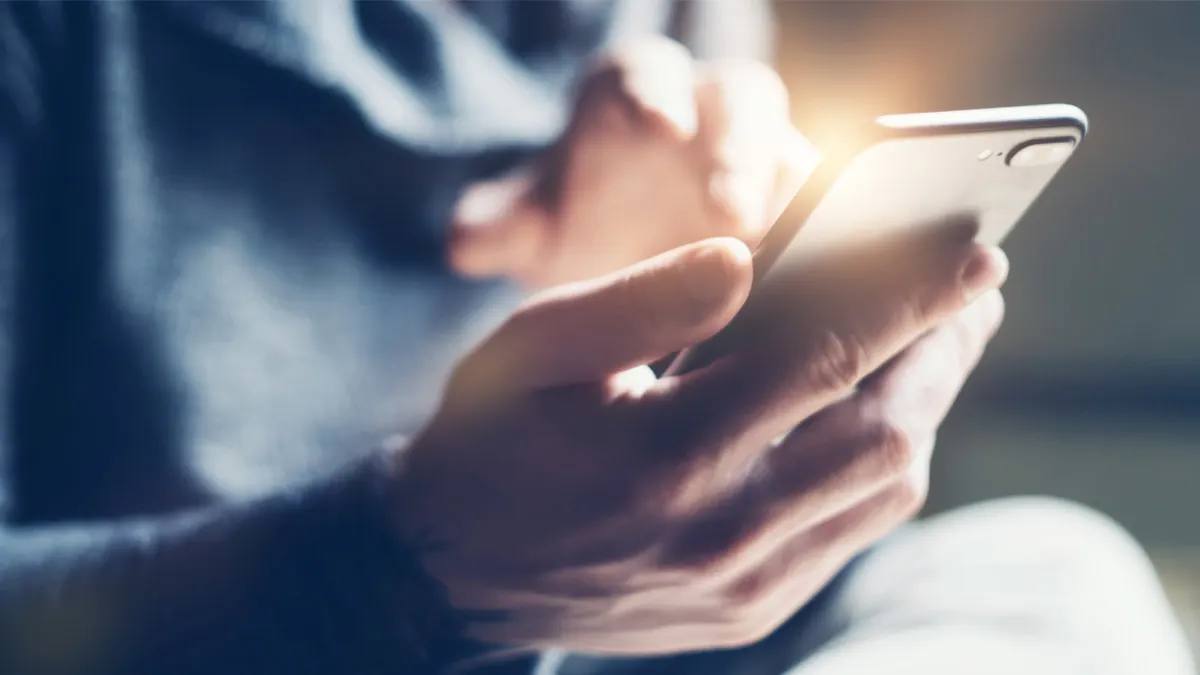 Eine Hand hält ein Smartphone.