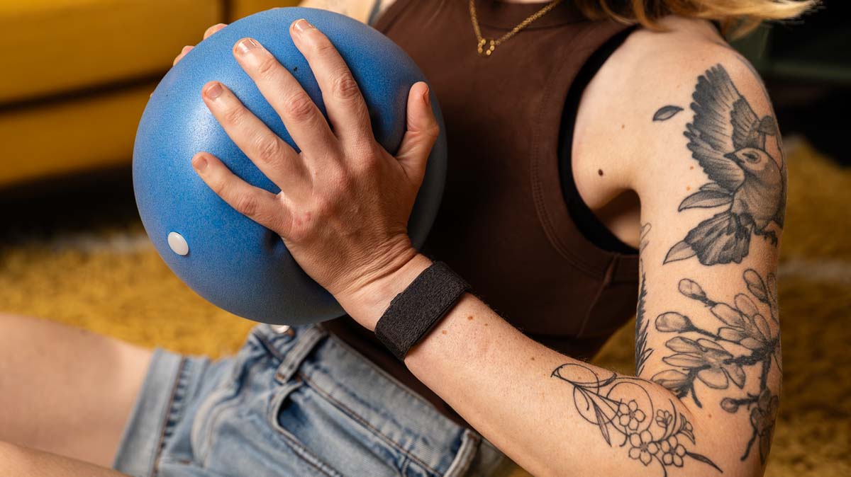Franzi macht eine Sportübung mit einem Pilates-Ball, dabei trägt sie das Garmin Cirqa am Handgelenk.