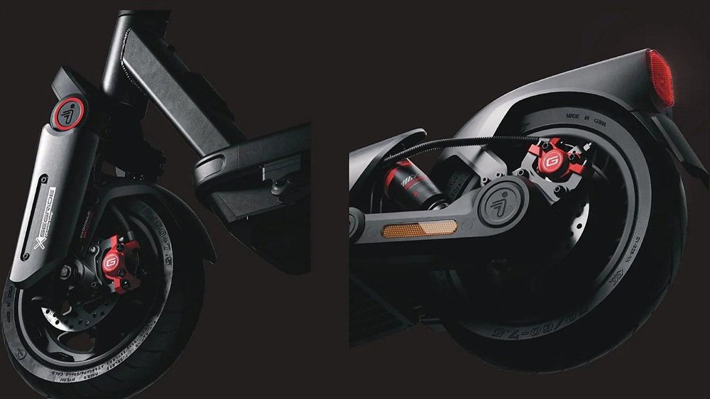 Detailaufnahme SEGWAY Ninebot MAX G3 D E-Scooter: Vorder- und Hinterrad mit breiten Reifen, kräftigen Federungen und roten Scheibenbremsen auf dunklem Hintergrund.