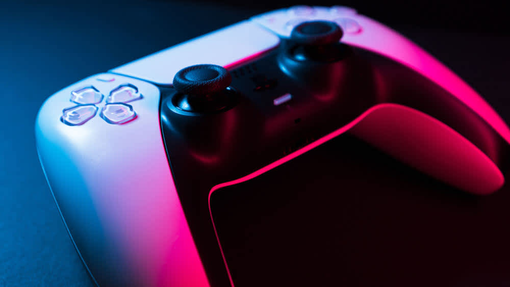 Ein PS5 Controller wird mit rotem Licht beleuchtet.