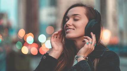 Eine Frau hört Musik mit Over-Ear-Kopfhörern.