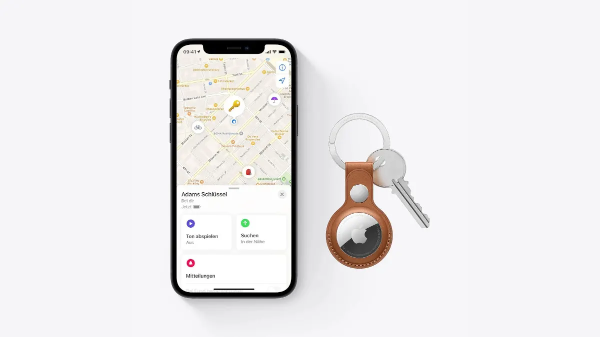 Auf weißem Grund liegen ein Smartphone mit Karten-App mit dem Text: "Adams Schlüssel" und ein Schlüsselanhänger mit AirTag und Schlüssel.