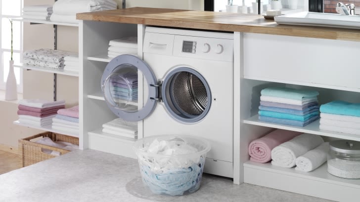 Ein offener Waschtrockner mit einem Wäschekorb