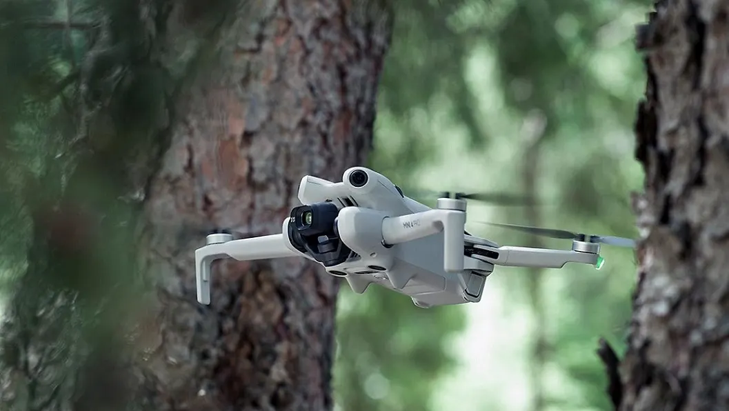 DJI Mini 4 Pro Fly More Combo Mini-Kameradrohne fliegt durch Wald