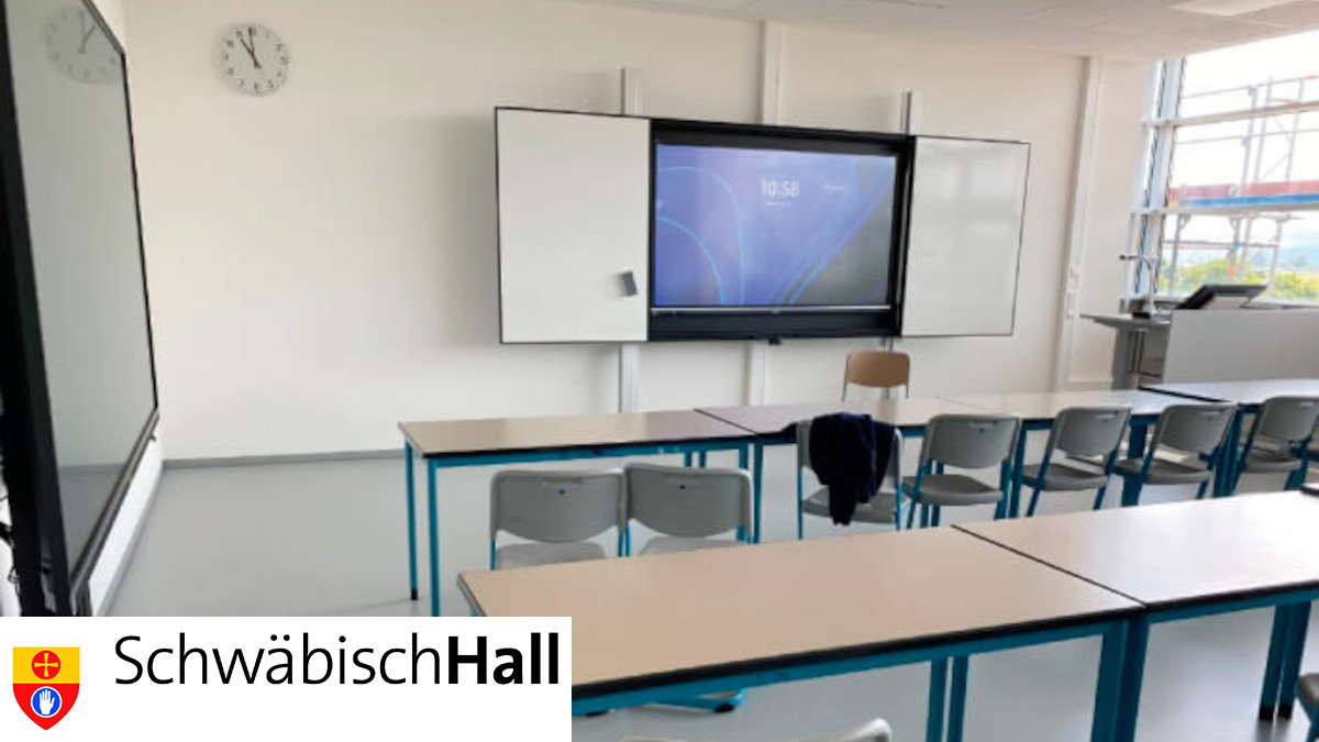 Ein digitales Klassenzimmer mit interaktivem Whiteboard an der Wand. Es ist das Wappen der Stadt Schwäbisch Hall zu sehen.