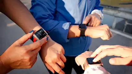 Nahaufnahme von vier Personen, die intelligente Uhren mit verschiedenen Armbändern tragen.