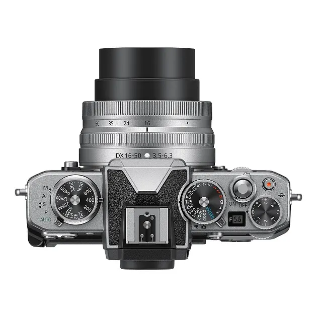 NIKON Z fc Kit Systemkamera mit Objektiv 16-50 mm, 7,5 cm Display Touchscreen, WLAN Draufsicht einer silbernen Kamera mit schwarzem Objektiv, Einstellrädern und Beschriftungen auf weißem Hintergrund.