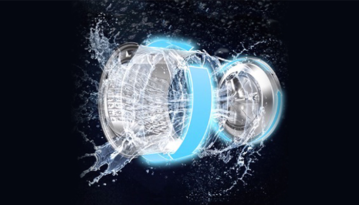 Eine silberfarbene Trommel mit blauem Akzent ist von Wasser umgeben, das gegen einen schwarzen Hintergrund spritzt.