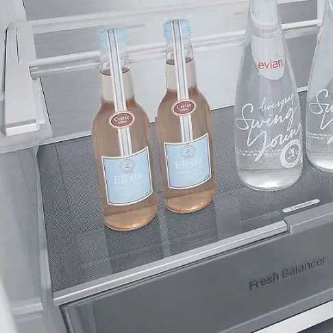 Im Kühlschrank stehen zwei Limonade- und zwei Wasserflaschen auf einem Regal über einer Schublade mit der Aufschrift "Fresh Balancer".