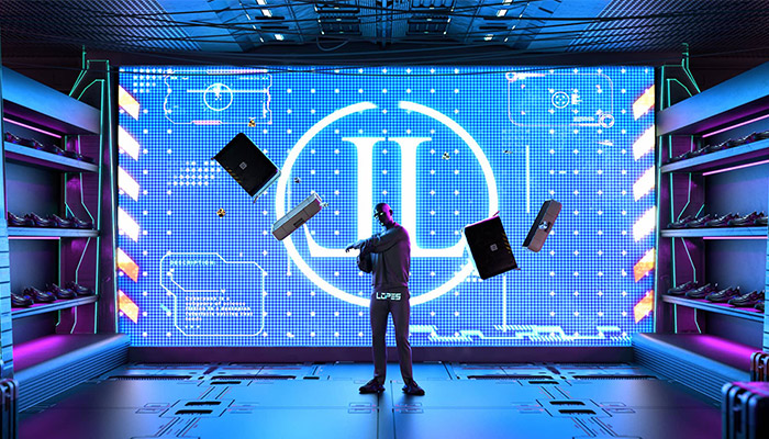 Person vor großem blauem Bildschirm mit Grafiken, umgeben von Regalen voller Schuhe in einem futuristischen Raum.