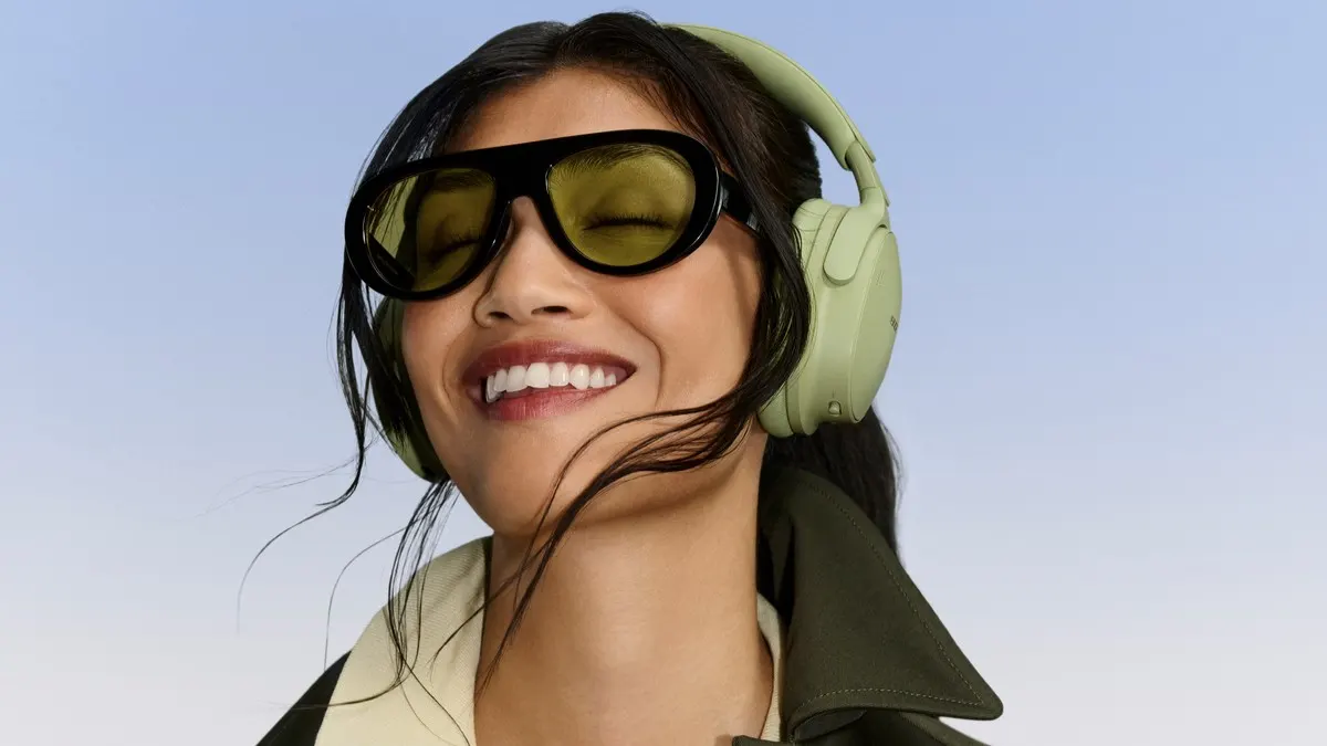 Eine lächelnde Frau trägt den Bose QuietComfort Kopfhörer (2. Gen.).