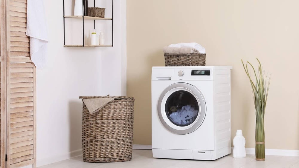 Wäschekorb und Handtücher neben einer Waschmaschine