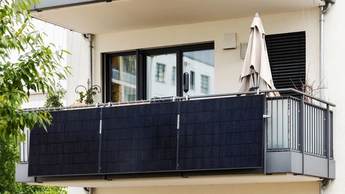 Ein Balkonkraftwerk ist am Geländer eines Balkons befestigt.
