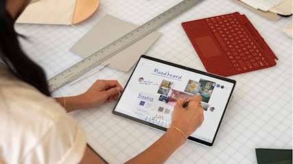 Eine Studentin schreibt auf ihrem Microsoft Surface, neben ihr liegt eine Lineal und eine Tastertur