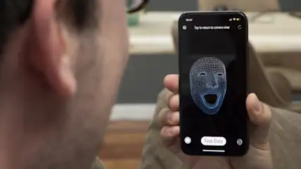 Eine Person hält ein Smartphone mit einer 3D-Gesichtsmodell-App vor ihr Gesicht.