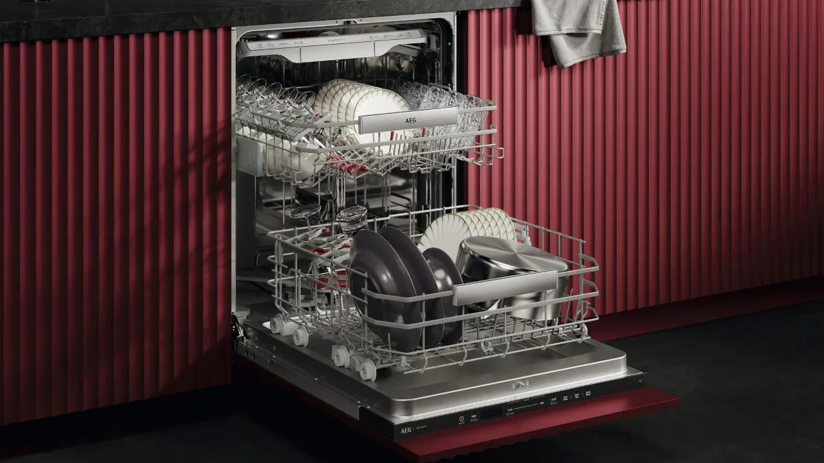 Der Geschirrspüler AEG GI9210X2CT Serie 9000 mit geöffneter Tür in einer roten Küchenzeile.