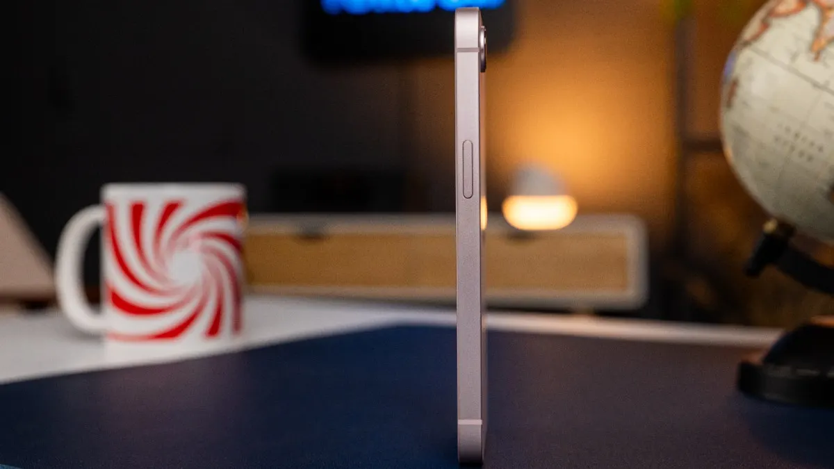 Das iPhone 17e steht hochkant auf einem Tisch und ist von der Seite zu sehen.