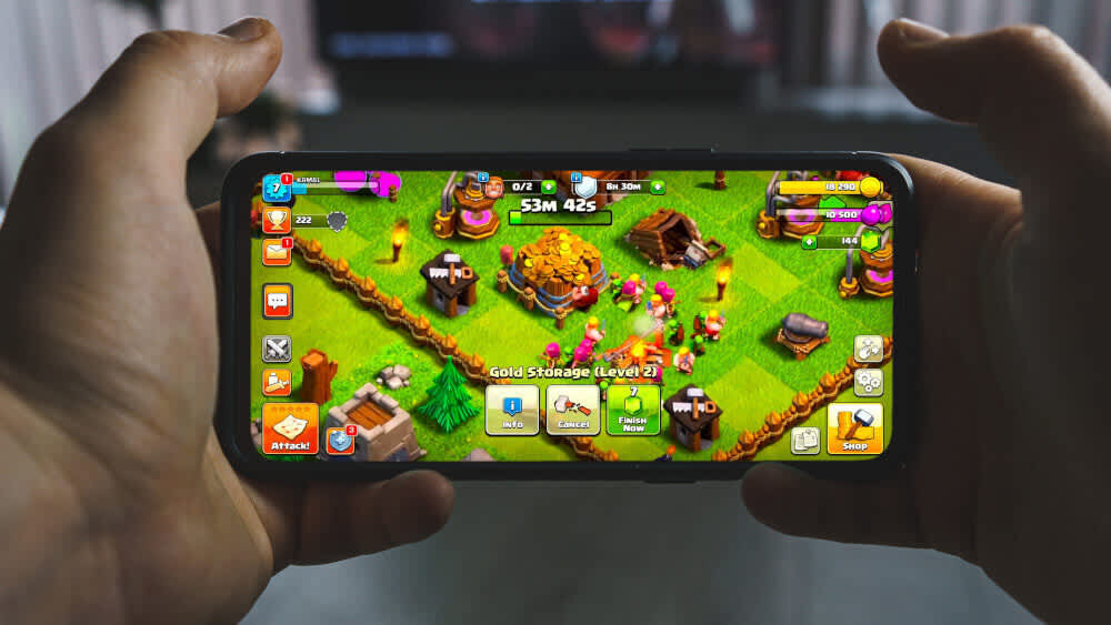 Eine Person spielt Clash of Clans auf einem Smartphone.
