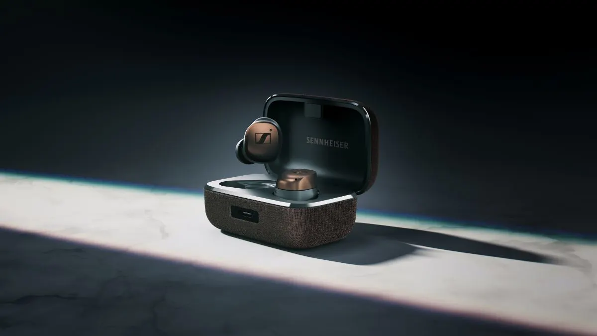 Die In-Ear-Kopfhörer Sennheiser Momentum True Wireless 4 liegen im aufgeklappten Ladecase und werden von einem Lichtstrahl in Szene gesetzt.