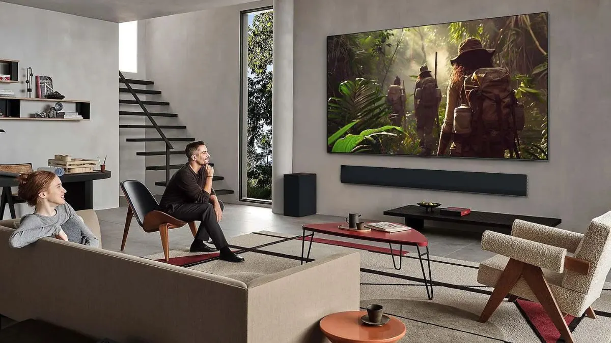 Eine Frau und ein Mann sitzen auf einem Sofa und sehen fern auf dem OLED-TV LG OLED G5.