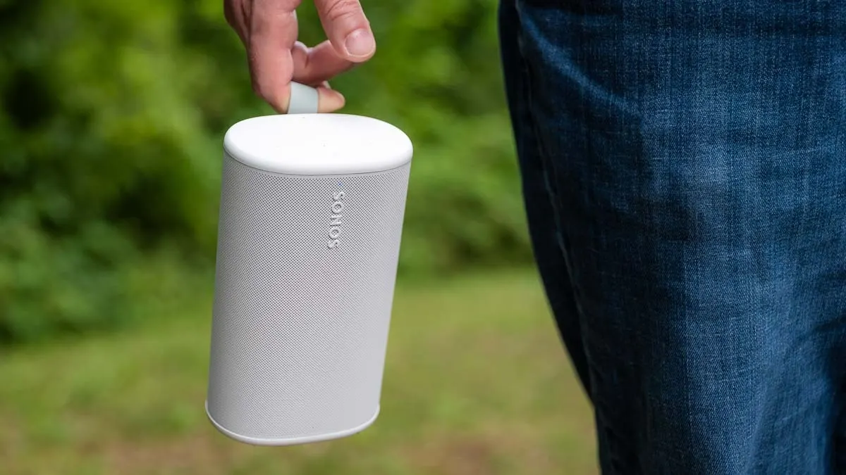 Eine Hand hält draußen in der Natur den Bluetooth-Lautsprecher Sonos Play.