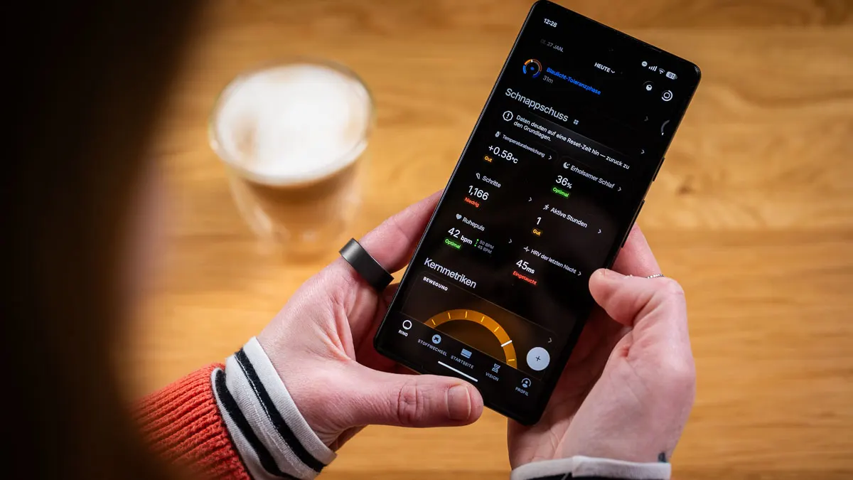 Franzi trägt den Ultrahuman Ring Air am linken Zeigefinger und schaut auf die Startseite der Ultrahuman-App.