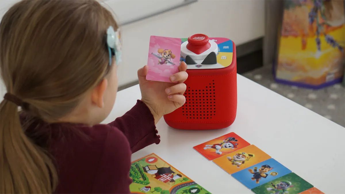 Franzis Tochter hält eine „Paw Patrol“-Spielkarte für die Toniebox 2 in der Hand.