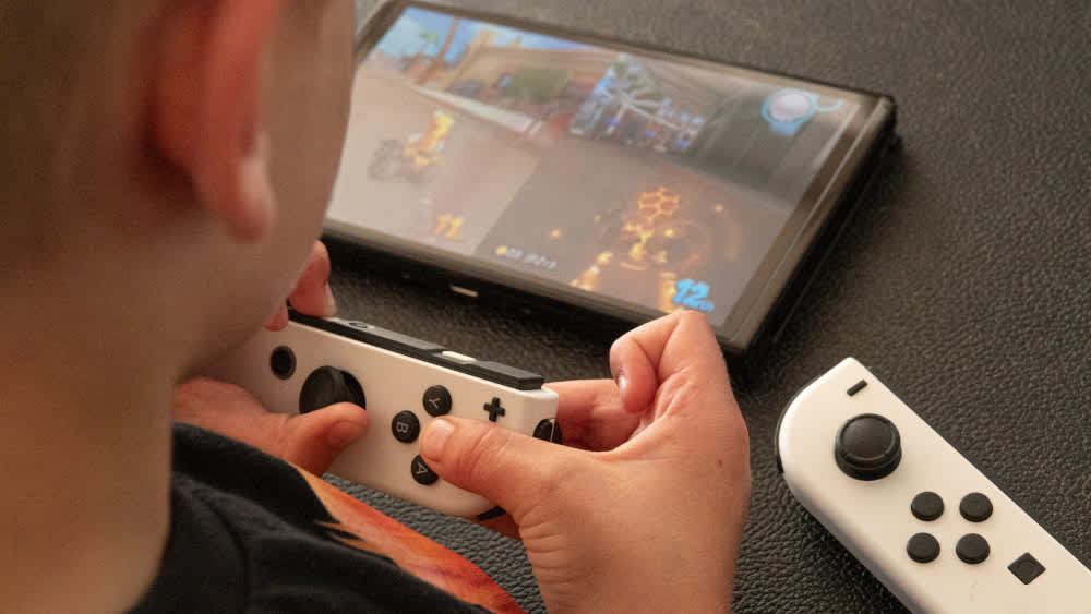 Ein Junge hält einen Joy-Con-Controller der Nintendo Switch in der Hand.