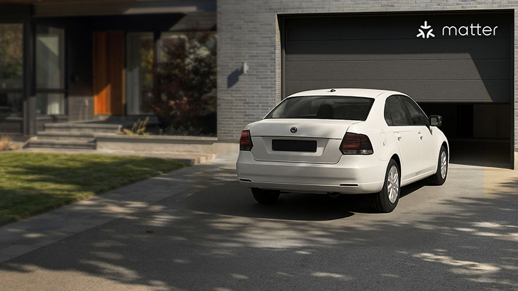 Modernes Einfamilienhaus mit einem sich öffnenden Garagentor, vor dem ein weißes Auto wartet, um in die Garage zu fahren; oben rechts das Matter-Logo.