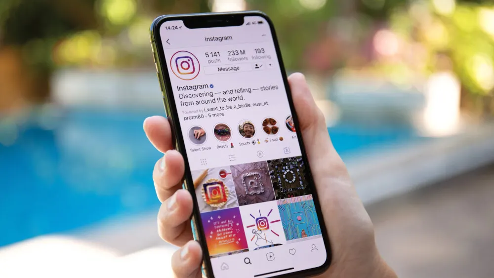 Ein Smartphone zeigt die Instagram-App. Der Instagram-Feed ist mit Beiträgen und dem Logo der App sichtbar.